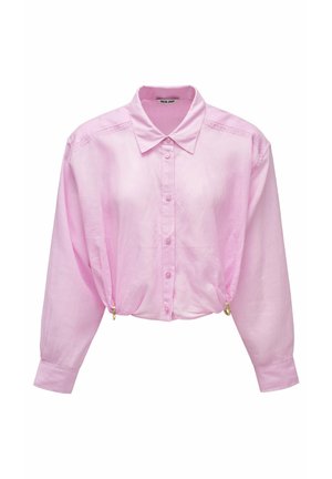 Blusa larga de manga larga en rosa claro con botones y cuello, bordado sutil en los hombros y costados fruncidos con anillos dorados.