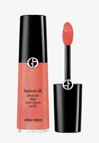 Giorgio Armani Luminous Silk Cheek Tint en corail, présenté dans un contenant cylindrique noir avec le logo ; comprend un applicateur avec un embout arrondi.