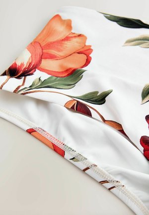 Blomstret stof med store orange og røde blomster på hvid baggrund, med grønne blade. Glat tekstur og syede kanter.