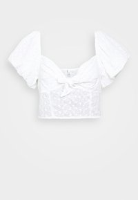 Blusa bianca corta realizzata in tessuto ricamato, con maniche a sbuffo, scollatura quadrata e dettagli di legatura sul davanti.