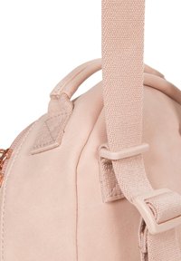 Rosa faux läder ryggsäck med en slät yta, topphandtag och justerbar tygrem med en plastspänne. Dragkedjestängning på sidan.