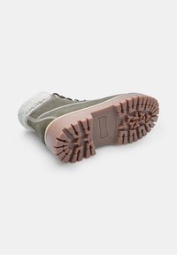 Stivale verde in suede con colletto in shearling bianco, design con lacci e suola in gomma marrone robusta con profilo profondo per una migliore trazione.