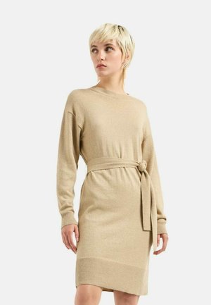 Abito in maglia beige con scollo rotondo, maniche lunghe e cintura in vita. Presenta orlo e polsini a coste, texture liscia e un leggero lucido.
