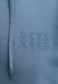 Φωτεινό γαλάζιο hoodie από απαλό ύφασμα, με ανάγλυφο, ανάγλυφο λογότυπο "JACK & JONES" στο μπροστινό μέρος και πλεκτό κορδόνι.