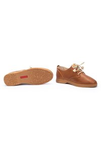 Scarpe in pelle marrone con finitura liscia, punta rotonda e lacci chiari in contrasto. Suola in gomma con battistrada e motivi dettagliati.
