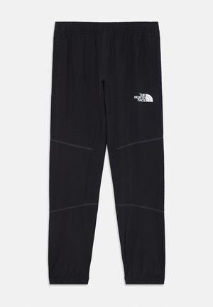 Pantalons de sport noirs en tissu léger, ornés d'un logo blanc, d'une taille élastique et de bandes grises le long des jambes.