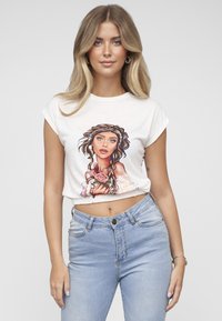 Hvit kort bomulls-T-skjorte med en fargerik illustrasjon av en kvinne som holder roser. Kombinert med lyseblå høytlivsjeans.