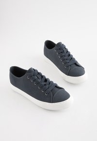 Tumši zilas auduma tenisa kurpes ar baltām gumijas zolēm un apaļiem purngaliem, ar sešām acu ailēm un atbilstošām šņorēm, ar teksturētu virsmu.