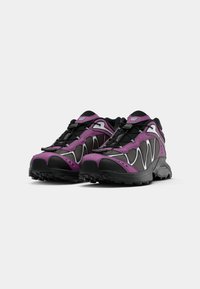 Purple and black sporty shoes with a textured upper, silver accents, and a durable sole designed for traction and stability.