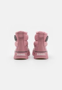 Rosa högskurna sneakers med texturerad tygöverdel, vadderad krage och gummisula med en svart och vit logotyp på hälen.
