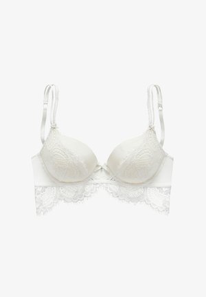 Reggiseno bianco con pizzo bordato, coppe modellate, spalline regolabili e un fiocco decorativo al centro. Dettagli in pizzo testurizzato lungo il bordo.