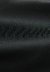 Tela negra con una textura suave y un brillo sutil. Presenta un patrón de tejido diagonal fino. Sin patrones visibles ni elementos metálicos.