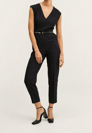 Černý overal s hlubokým výstřihem do V, krátkými rukávy a přiléhavým střihem. Má tenký pásek s řetízkovým detailem a zúžené nohavice do kotníků.