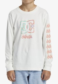 Weißes langärmliges T-Shirt mit bunten Grafiken auf der Vorderseite und entlang des rechten Ärmels. Hergestellt aus weicher Baumwolle mit lockerer Passform.