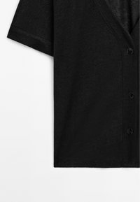Svart button-up skjorta i mjukt material med v-ringning och korta ärmar; inkluderar dekorativa svarta knappar.