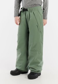 Winddichte, losvallende groene skibroek met een elastische tailleband, riem en zijzakken. Gemaakt van duurzaam, waterafstotend materiaal.