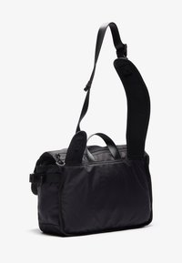 Black nylon messenger bag with adjustable padded shoulder strap, dual top handles, zip closure, and a structured rectangular shape.