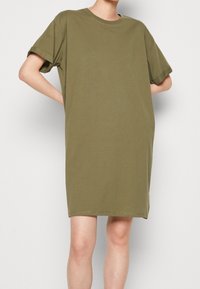 Oliwkowa bawełniana sukienka T-shirt z krótkimi rękawami, okrągłym dekoltem i luźnym krojem. Gładka tekstura i długość do kolan.