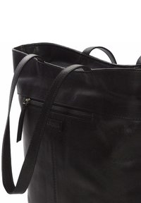 Bolso tote de cuero negro con una textura suave, dos asas para el hombro y un bolsillo exterior con cremallera. Diseño minimalista.