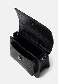 Sac en cuir noir gaufré crocodile avec fermeture à rabat, double compartiments intérieurs, et détail à bouton-pression argenté brillant.