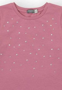 Camiseta de algodón rosa con cuello redondo y cristales de imitación plateados dispersos por el frente, creando un diseño texturizado.