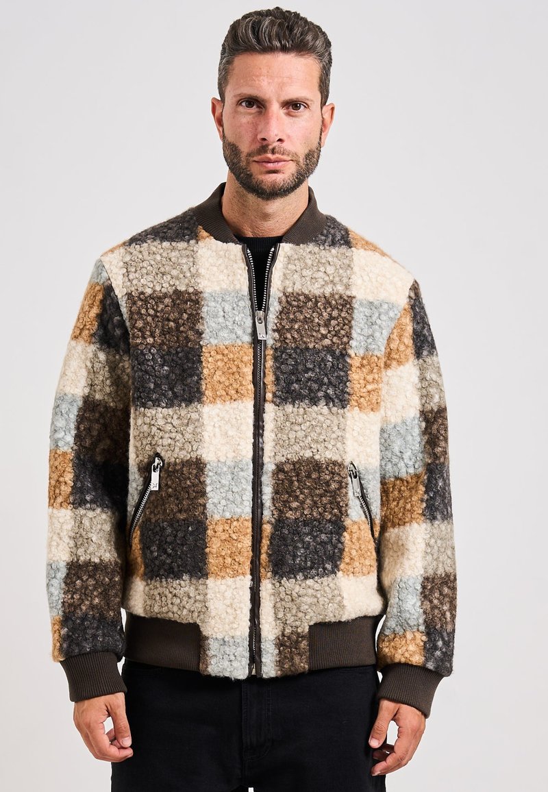 Giacca bomber a quadri marrone e beige realizzata in tessuto testurizzato, con chiusura a zip e polsini a costine, tasche e colletto.