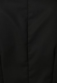 Tessuto nero con una superficie liscia, caratterizzato da una cucitura verticale al centro. Nessun motivo o accessorio visibile.
