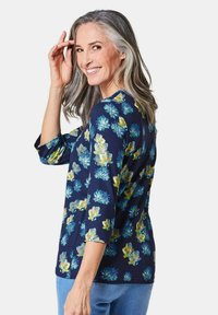 Navy-Hemd mit floralem Muster in Blau- und Gelbtönen, mit rundem Ausschnitt und Dreiviertelärmeln. Weicher Stoff.