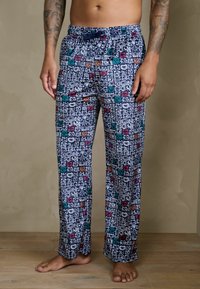 Spodnie od piżamy męskiej w granatowym kolorze z kolorowymi wzorami kreskówkowych twarzy. Elastyczny pas z troczkiem, luźny krój.