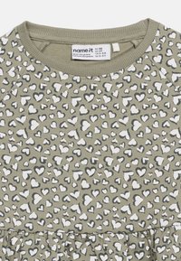 Παιδικό φόρεμα λαδί με μοτίβο από λευκές και σκουρόχρωμες γκρι καρδιές και στρογγυλή λα ιμόκοψη.