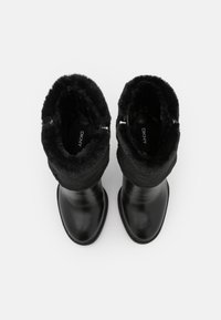 Černé kožené kotníkové boty s texturovaným černým umělým kožíškem na límci a stříbrnými zipovými detaily, s hladkým a lesklým povrchem.