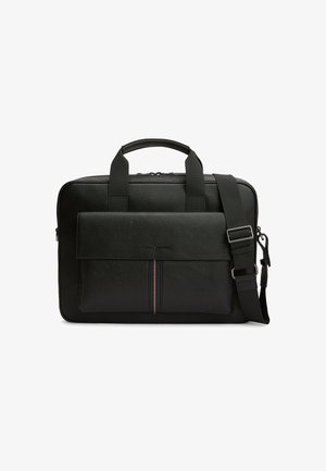 Czarna tekturowa skórzana teczka z górnymi uchwytami, przednią kieszenią z klapką i regulowanym paskiem na ramię z metalową klamrą.