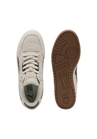 Baskets en suède blanc avec des accents noirs, semelles en caoutchouc texturé, détails perforés sur le bout et marquage doré sur le côté.