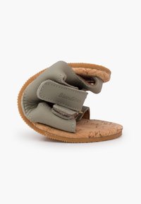 Sandal in pelle verde con sottopiede in sughero, forma curva, singolo cinturino con chiusura in velcro e suola in gomma testurizzata.