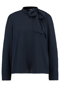 T tumma sininen pitkähihaine paita, jossa on korkea kaulus ja koristeellinen nauha solmittuna oikeaan olkapäähän.