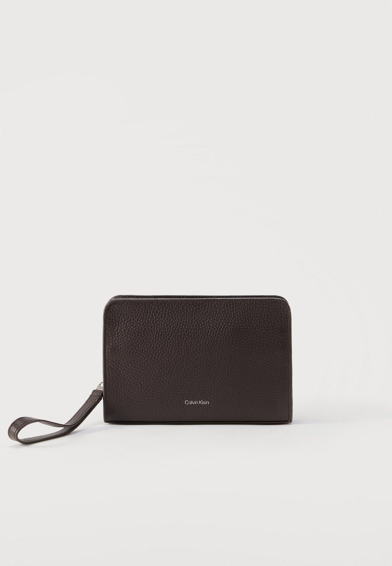 Μαύρο πορτοφόλι χειρός από δερματίνη με υφή, με φερμουάρ κλεισίματος και μικρό λογότυπο Calvin Klein στο κέντρο της μπροστινής πλευράς.