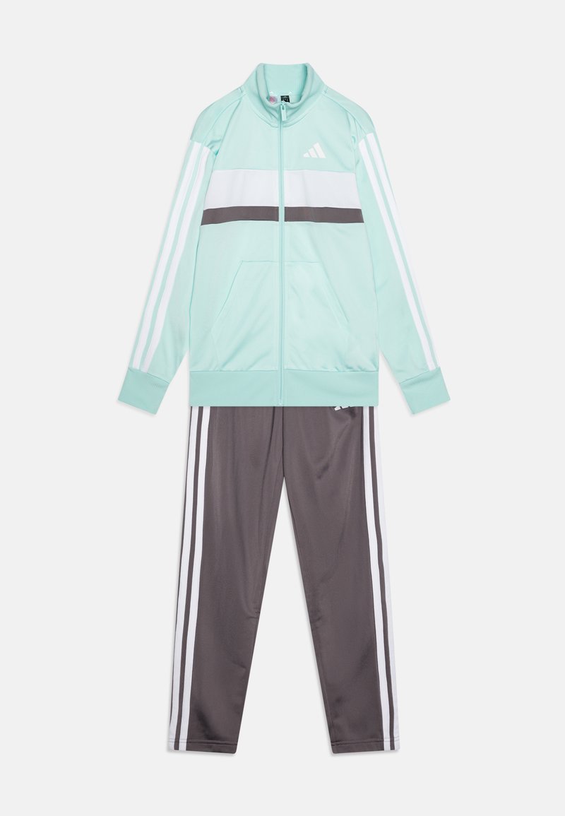 Mintgrön träningsoverall med vita ränder och grå detaljer. Har en zip-up jacka med fickor och matchande grå byxor med tre ränder.