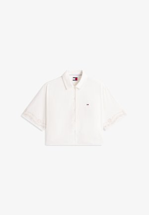 Camisa blanca de manga corta con botones y cuello, bordes sutiles bordados en las mangas y un pequeño logo de Tommy Hilfiger en el pecho.