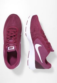 Baskets de course en mesh bordeaux avec des accents blancs, bout rond, design à lacets et semelle rembourrée. Présente un logo sur la languette et sur le côté.