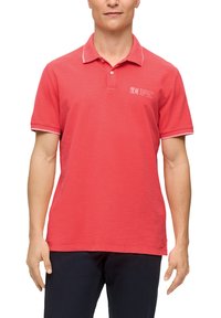 Czerwona koszulka polo z prążkowanym kołnierzykiem, białymi akcentami i logo. Wykonana z gładkiego materiału, z krótkimi rękawami, prostym krojem i luźnym fasonem.