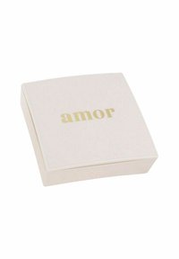 Packaging cuadrada, suave de color rosa con una superficie lisa y un texto dorado que dice "amor" en la parte superior. Bordes redondeados, diseño minimalista, sin detalles adicionales.