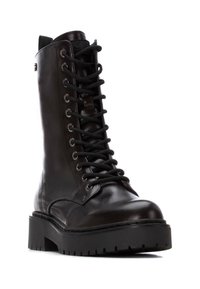 Bota de combate de cuero negro con punta redonda, parte delantera con cordones, ojales de metal y una suela de goma gruesa con surcos profundos para mayor tracción.