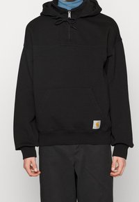 Felpa nera con cappuccio, colletto con zip, tasca a marsupio, polsini a coste e etichetta logo in tessuto sull'orlo. Realizzata in materiale morbido.