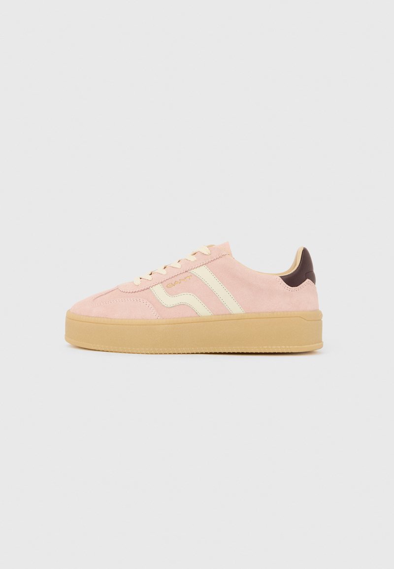 Zapatilla deportiva de ante rosa claro con suela de goma beige, cordones crema, rayas laterales crema, acento en el talón marrón oscuro y logotipo "GANT" en el lateral.
