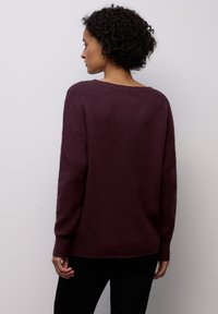 Maglione lavorato a maglia color granata con vestibilità rilassata, scollo ampio e maniche lunghe, caratterizzato da polsini a coste e una texture morbida.