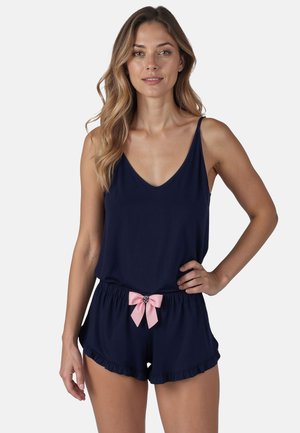 Set de pijama bleumarin format dintr-un top fără mâneci cu decolteu în V și pantaloni scurți asortați cu margini volan și o fundiță roz la talie.