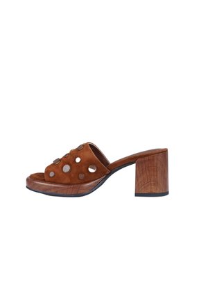 Mule de ante marrón con puntera abierta, tachuelas metálicas circulares, tacón de bloque de madera y suela de plataforma, mostrado en perfil lateral sobre fondo blanco.