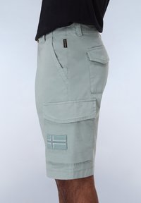 Pantaloni cargo grigi chiari con multiple tasche, un patch decorativo con motivo a bandiera e una vestibilità comoda. Realizzati in tessuto resistente.