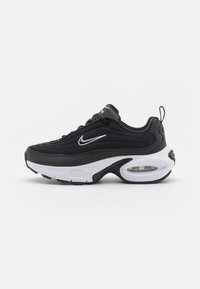 Black athletic sneaker with a textured upper, white sole, and visible air cushioning. Features a rounded toe and white swoosh logo on the side.