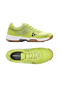 Limegröna träningsskor med mesh och syntetmaterial, med en vadderad sula, svarta detaljer och snörning.